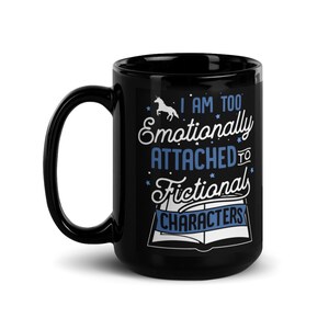 May include: Black coffee mug with a white unicorn and the text "I am too emotionally attached to fictional characters" in blue and white lettering.