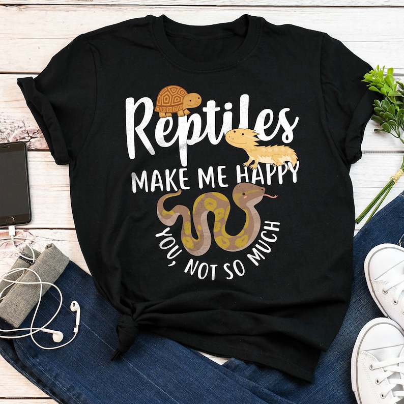 May include: Black t-shirt with white text that reads "Reptiles make me happy, you not so much". The shirt features a cartoon turtle, lizard, and snake.