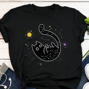 May include: Black t-shirt featuring a graphic of a black cat with a constellation design. The cat is surrounded by stars and planets.
