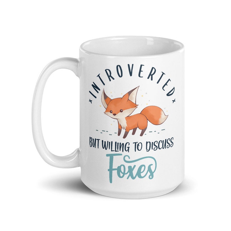May include: White ceramic mug featuring a fox illustration and the text "Introverted but willing to discuss foxes".