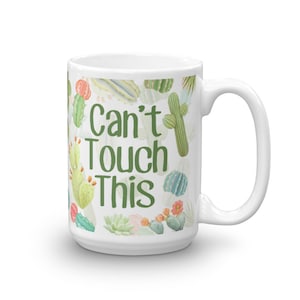 May include: White ceramic mug with a green cactus print and the text "Can't Touch This".