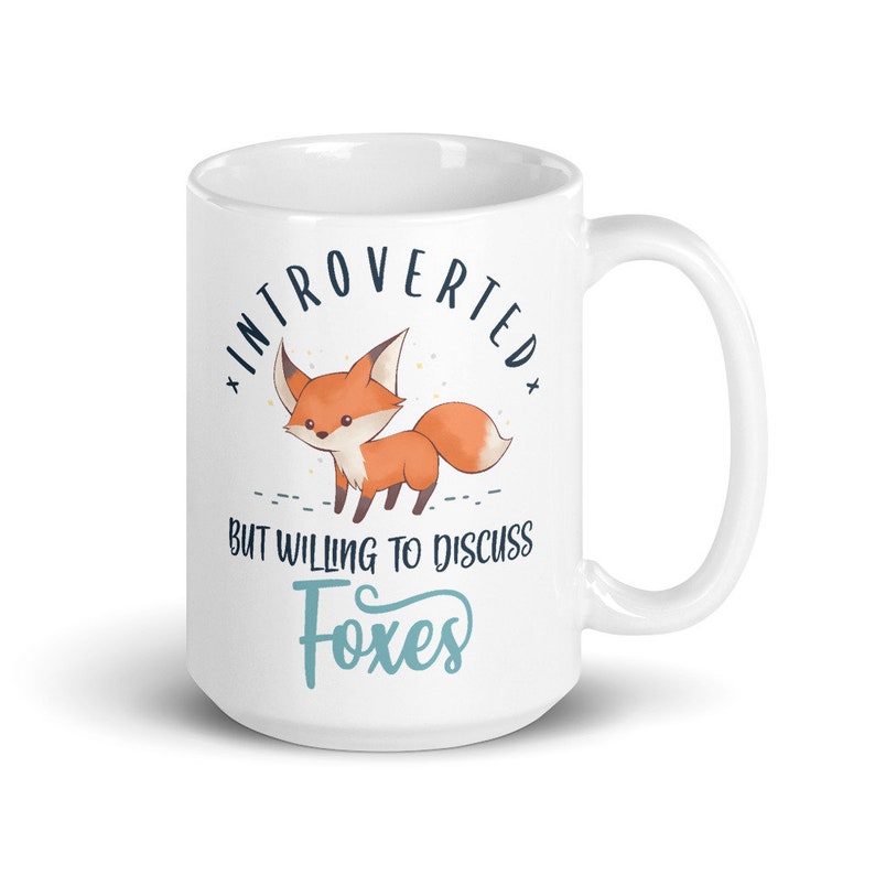 May include: White ceramic mug featuring a fox illustration and the text "Introverted but willing to discuss foxes".