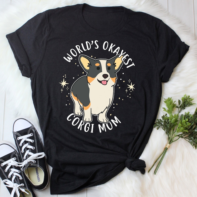 May include: Black t-shirt with a cartoon corgi and the text "World's Okayest Corgi Mum".