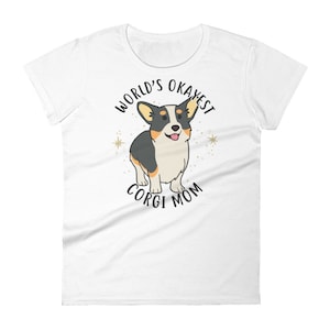 May include: White t-shirt with a black and white cartoon corgi dog and the text "World's Okayest Corgi Mom".