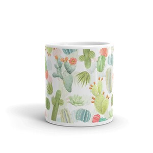 May include: White ceramic mug with a repeating pattern of green, pink, and yellow cacti and succulents.