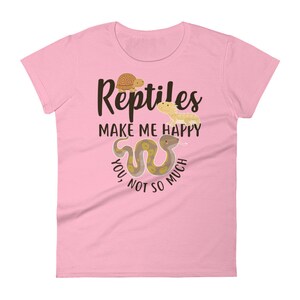 May include: Pink women's t-shirt with a brown snake, a turtle, and a lizard. The text on the shirt reads "Reptiles Make Me Happy You Not So Much."