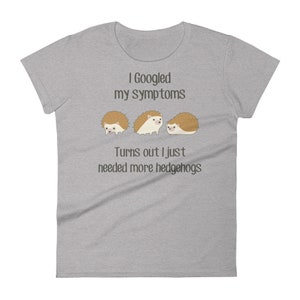 May include: A gray t-shirt with the text "I Googled my symptoms Turns out I just needed more hedgehogs" and three cartoon hedgehogs.