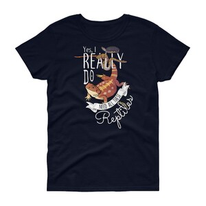 Puede incluir: Una camiseta azul marino para mujer con un gr&aacute;fico blanco de un drag&oacute;n barbudo, una serpiente y una tortuga. El texto en la camiseta dice "S&iacute;, realmente necesito todos estos reptiles."