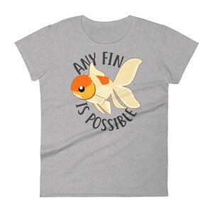 May include: A gray t-shirt with a cartoon goldfish and the text "Any fin is possible".