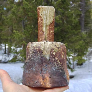 May include: A set of three ceramic mugs with a speckled, matte finish. The mugs are in shades of cream, light gray, and dark gray. Each mug has a simple, minimalist design and a rounded handle.