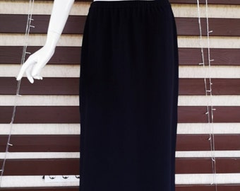May include: A long black maxi skirt with a simple design. The skirt is made of a smooth, flowing fabric.