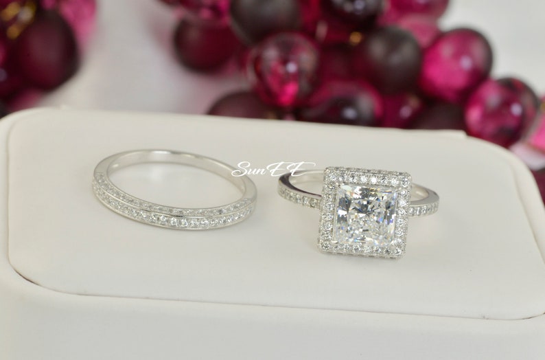 May include: A set of two silver wedding bands with a square-shaped diamond ring and a band with two rows of small diamonds.