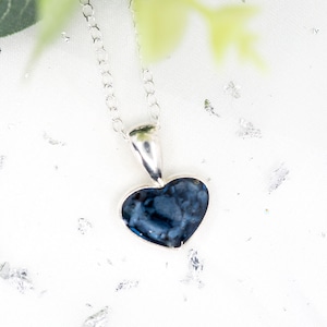 Peut inclure: Un collier avec un pendentif en forme de cœur en argent avec une incrustation de pierre marbrée bleu foncé.