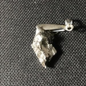 May include: A silver pendant shaped like a rough, jagged rock with a silver bail.