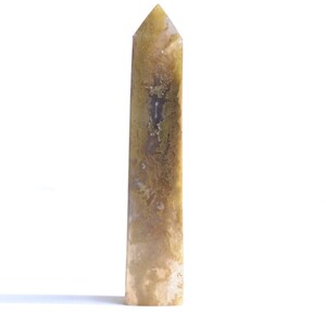 May include: A tall, pointed, light brown and yellow crystal with a smooth, polished surface.