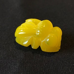 Peut inclure: Un pendentif en jade sculpté jaune en forme de fleur stylisée.