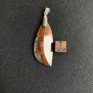 Könnte beinhalten: Ein brauner und weißer Achat-Anhänger mit einer silbernen Öse. Der Anhänger ist etwa 1 cm lang.