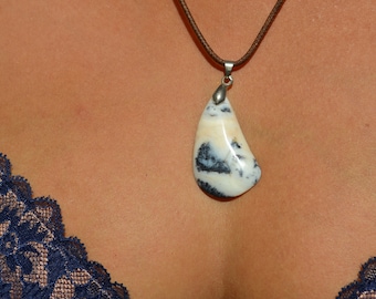 May include: A white and black agate pendant on a brown leather cord necklace.