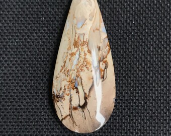 Op de afbeelding: Een traanvormige cabochon van bruin, wit en grijs agaat met een swirl-patroon.