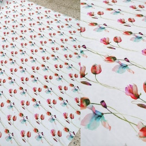 Pode incluir: Tecido branco com um padr&atilde;o repetido de flores de aquarela rosa, vermelha e azul com caules verdes.