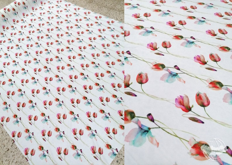 Pode incluir: Tecido branco com um padr&atilde;o repetido de flores de aquarela rosa, vermelha e azul com caules verdes.