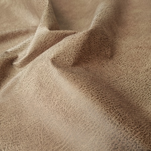May include: Close-up of a brown faux leather fabric with a textured surface.