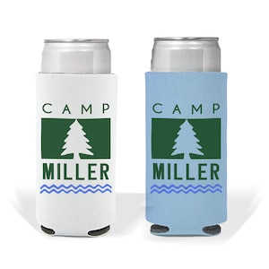 May include: Two white and blue can coolers with the text "CAMP MILLER" and a green pine tree graphic. The can coolers are designed to keep drinks cold.