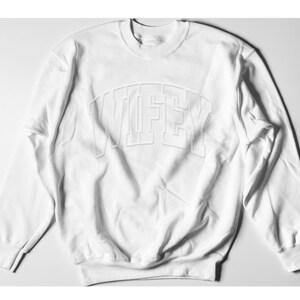 May include: White sweatshirt with a raised, white "WIFEY" graphic on the front.