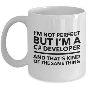 May include: White ceramic coffee mug with a black design that reads "I'm not perfect but I'm a C# developer and that's kind of the same thing."