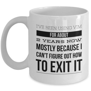 May include: White ceramic coffee mug with black text that reads "I've been using Vim for about 2 years now mostly because I can't figure out how to exit it."