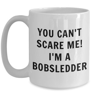 May include: White ceramic coffee mug with black text that reads "You can't scare me! I'm a bobsledder."