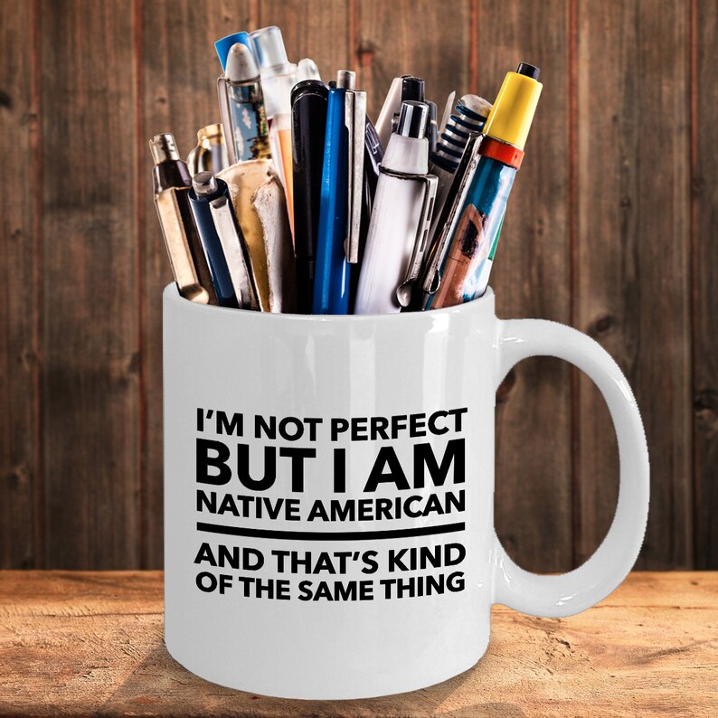 May include: White ceramic coffee mug with a black inscription that reads "I'm not perfect but I am Native American and that's kind of the same thing".