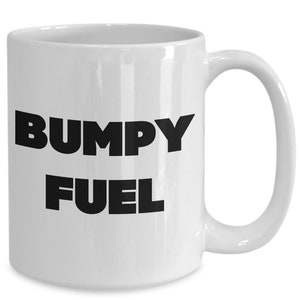 May include: White ceramic coffee mug with black text that reads "BUMPY FUEL".