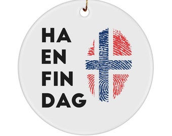 May include: White ceramic ornament with the text "HA EN FIN DAG" in black lettering and a fingerprint design with the colors of the Norwegian flag.