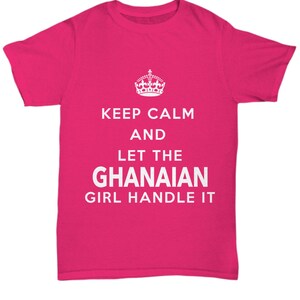 May include: A pink t-shirt with the text "Keep Calm and Let the Ghanaian Girl Handle It" in white. A crown graphic is above the text.