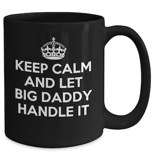 May include: Black ceramic coffee mug with a white crown and the text "Keep Calm and Let Big Daddy Handle It".