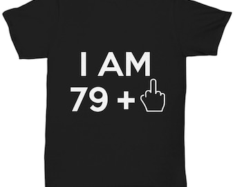 May include: Black t-shirt with white text that reads "I AM 79 +" with a middle finger emoji.