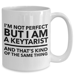 May include: White ceramic coffee mug with black text that reads "I'm not perfect but I am a keytarist and that's kind of the same thing."