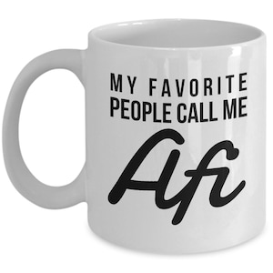 May include: White ceramic coffee mug with black text that reads "My favorite people call me Afi".