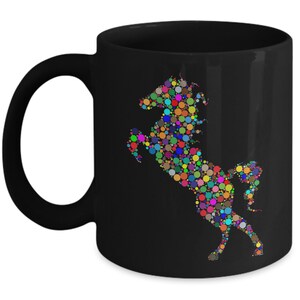 May include: Black ceramic coffee mug with a colorful horse design made of circles. The horse is in a rearing pose.
