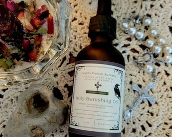 May include: A dark brown glass bottle with a dropper top and a label that reads "Angels Present Alchemy", "Vintage Apothecary", "Spiritual Products", "Archangel Michael", "Holy Banishing Oil", "Supports the removal of disharmony & negative energies", "Organic Herbs & Flowers & Single Match Blend Oil", "4 fl oz", "Made with Love".