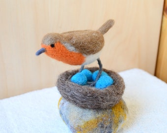 Robin felt bird with nest and eggs on stone