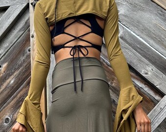 May include: A mustard yellow long-sleeved crop top with a lace-up back and bell sleeves. The top is paired with a matching olive green maxi skirt.