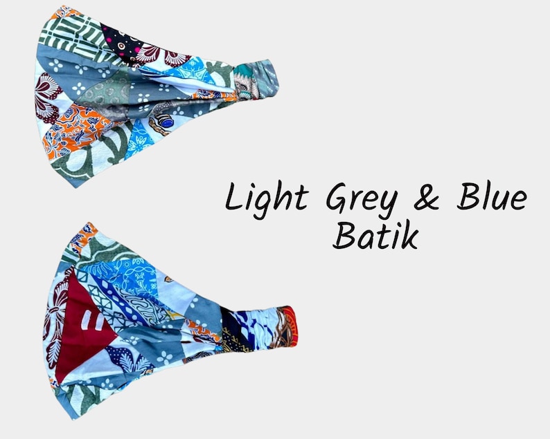 May include: Two light grey and blue batik fabric headbands. The fabric is patterned with a patchwork design.