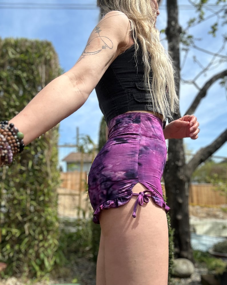Puede incluir: Shorts de color morado con estampado tie-dye, dobladillo con volantes y un lazo en el lateral. Los shorts est&aacute;n hechos de una tela suave y el&aacute;stica.