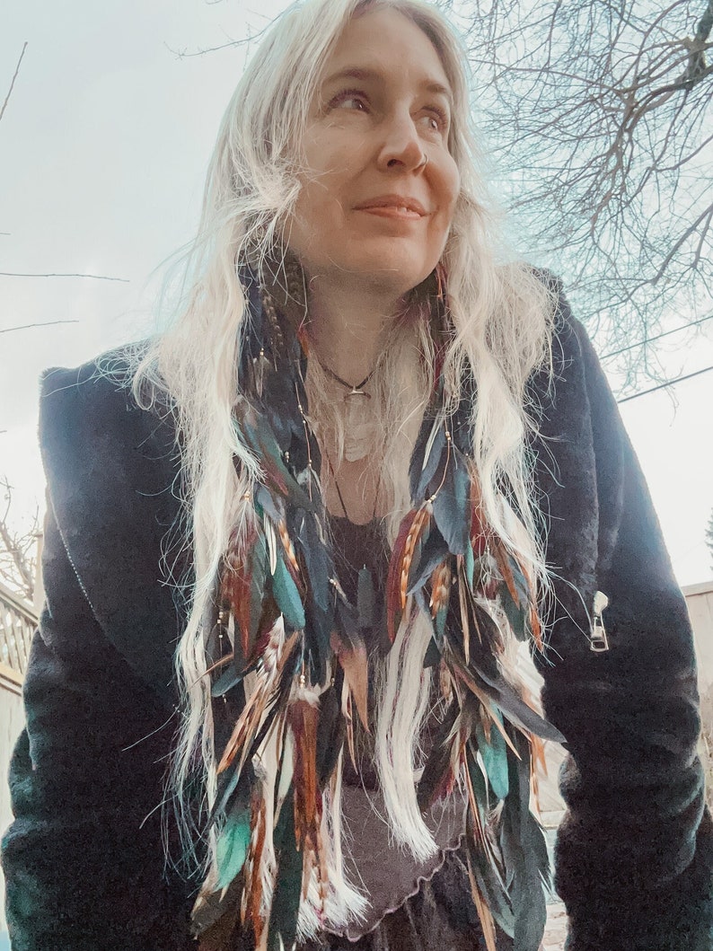 Detail of natural feathers on long handmade boho feather drop earrings perfect for festival fashion