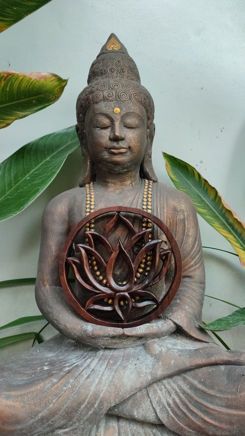 May include: A brown wooden lotus flower carving with gold accents, held by a seated Buddha statue.