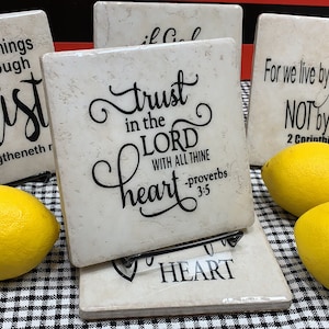 May include: Set of six white ceramic coasters with black inspirational quotes. The quotes include "I can do all things through Christ", "Trust in the Lord with all thine heart", "For we live by faith, not by sight".