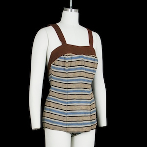 May include: Vintage one-piece swimsuit with brown straps and trim. The bodice features horizontal stripes in shades of blue, tan, and black. The swimsuit is displayed on a white mannequin against a black background.