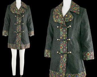 May include: A gray coat with a colorful geometric pattern on the collar, cuffs, and down the front. The coat has gold-colored buttons and is displayed on a mannequin. The coat is a vintage style.